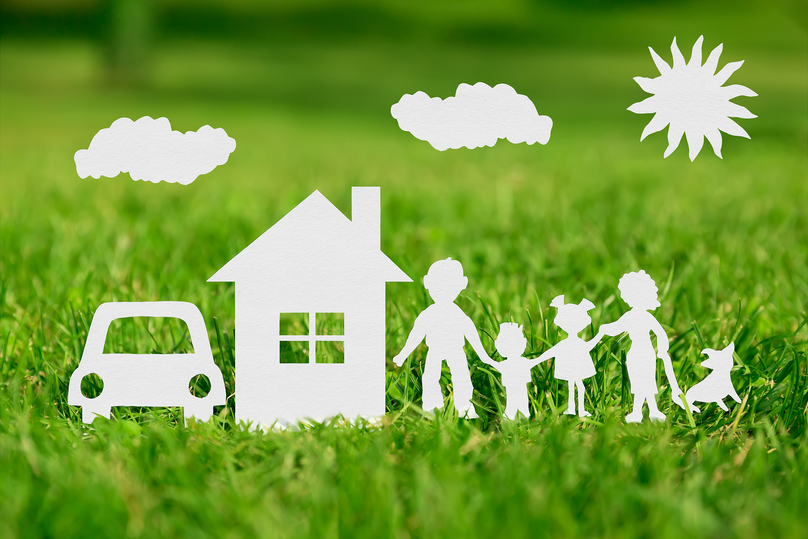 Paper cut of family with house and car on green grass