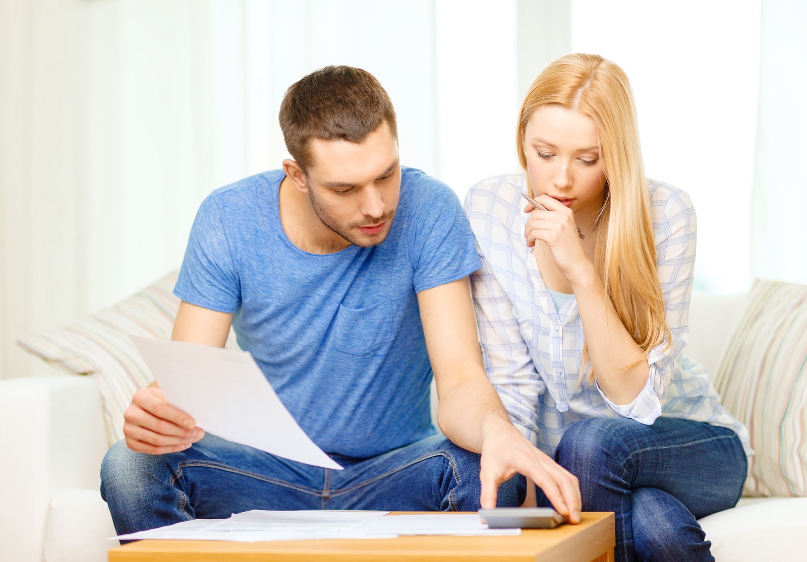 tax, finances, family, home and happiness concept - busy couple with papers and calculator at home