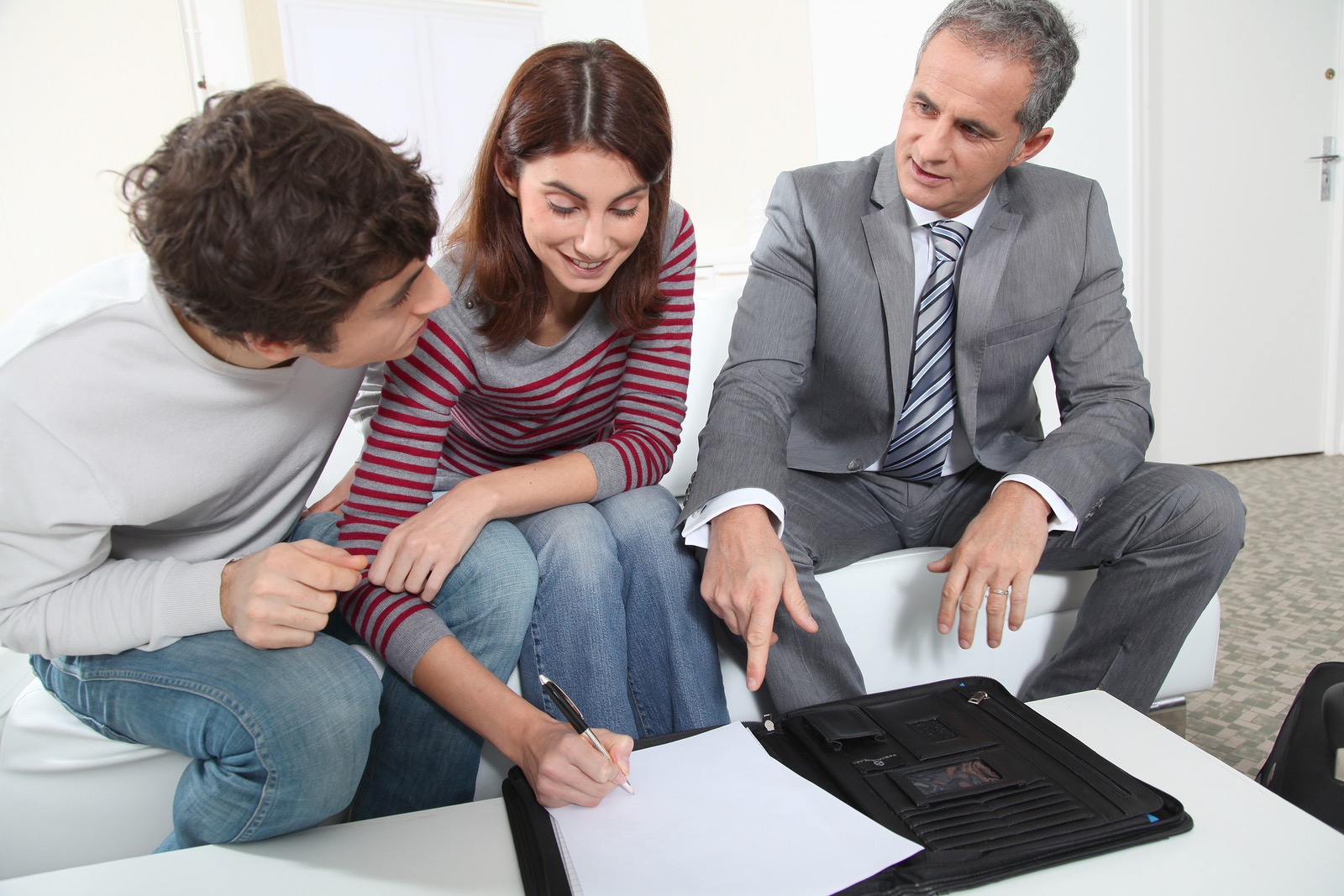 Young couple signing renting contract with real estate agent