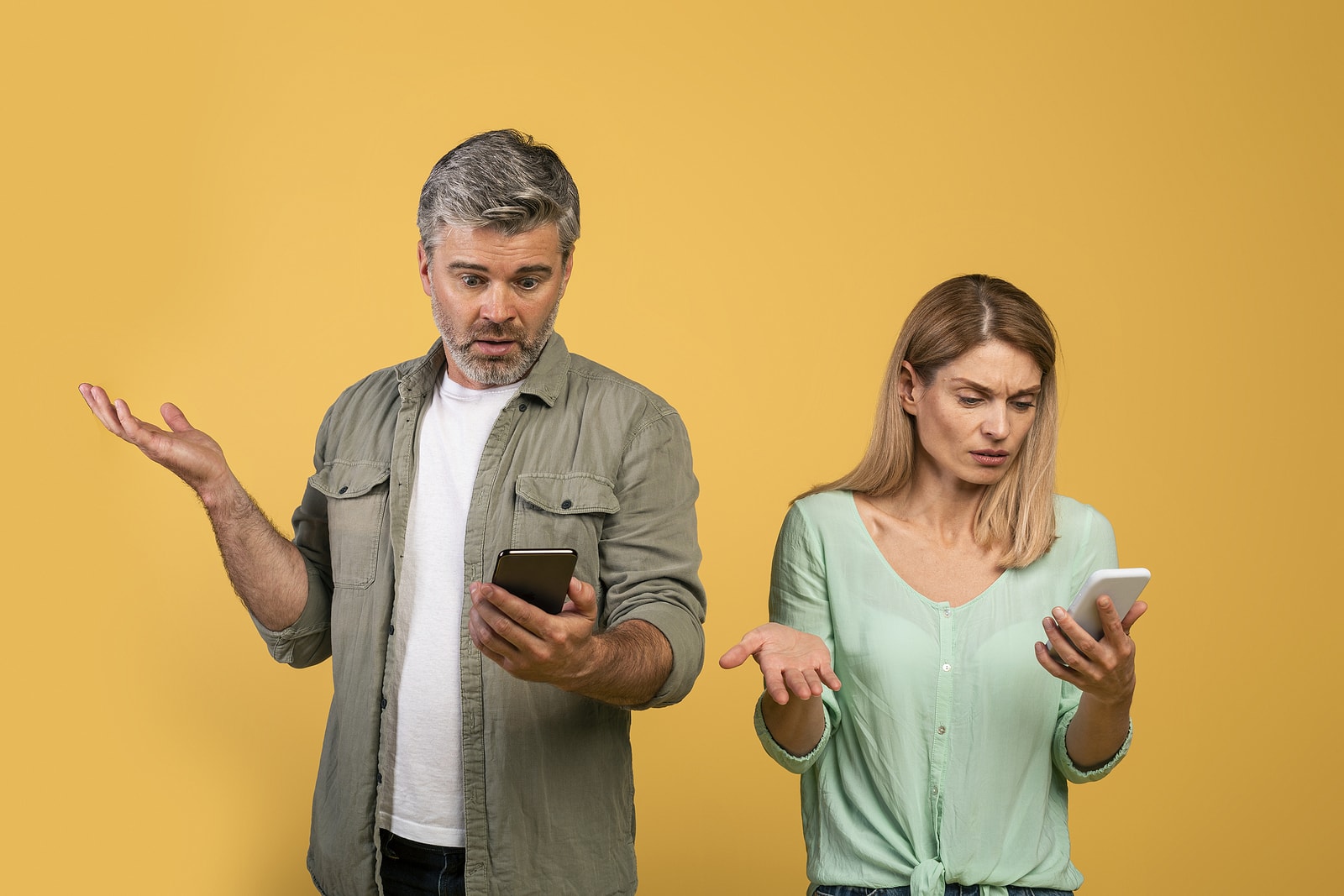 Confused couple checking their phones