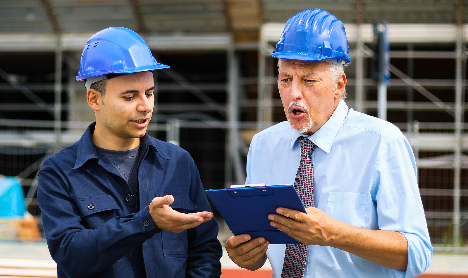 Senior engineer blaming his colleague for delay in construction site