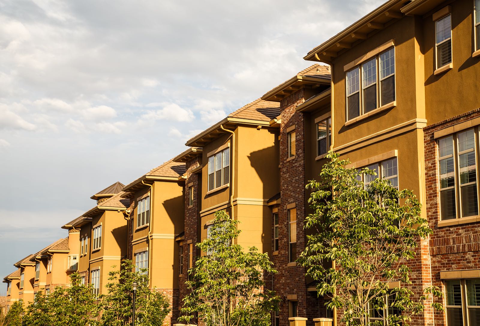 Modern Stucco and Brick Condos Under Summer Sky