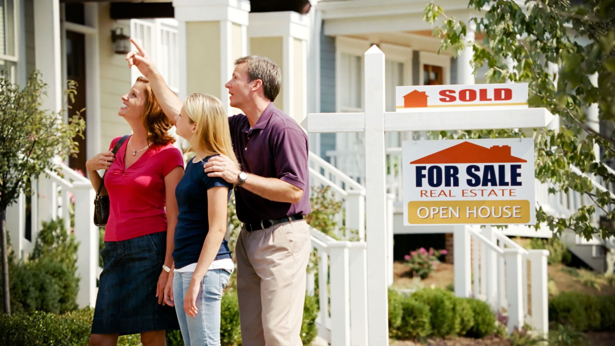 A young family looks up at their new home.