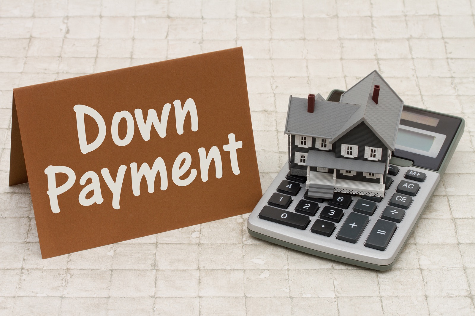 Home Mortgage Down Payment A gray house brown card and calculator on stone background with text Down Payment